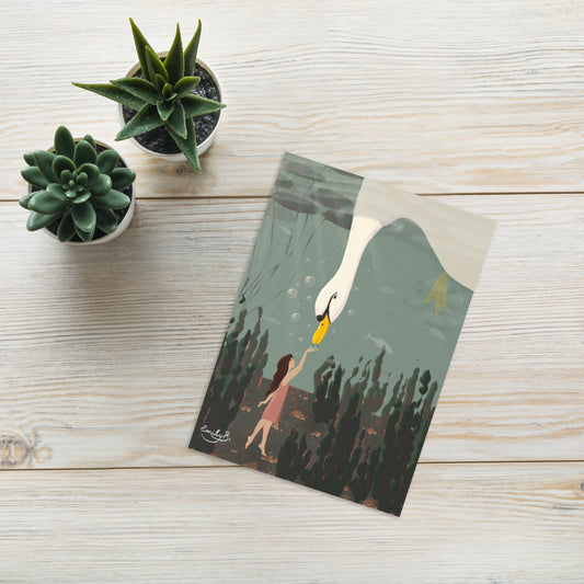 Greeting card with a swan and person illustration on a wooden surface with succulents.