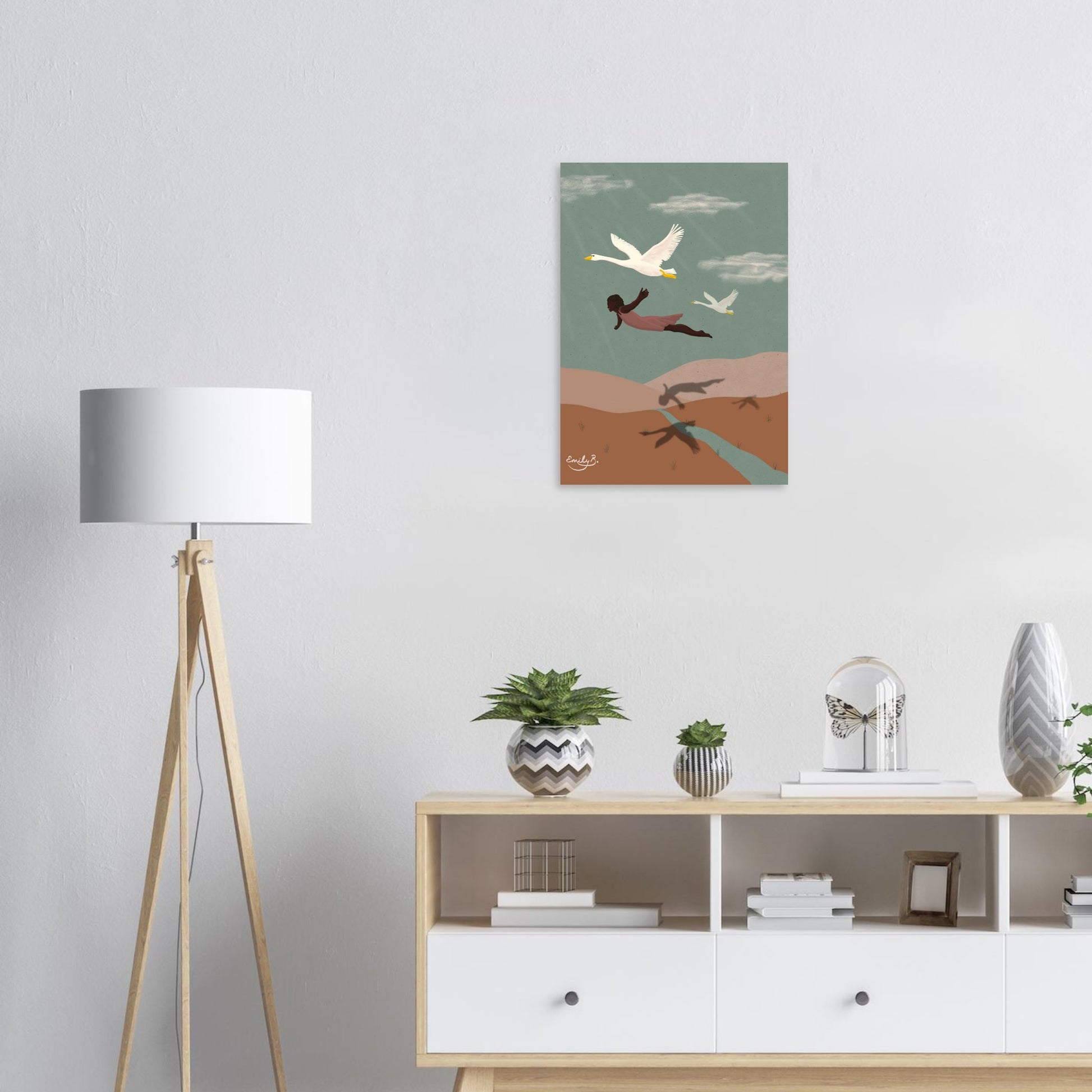 Interior mockup of Flying With Swans art print, featuring a Black woman in a pink dress flying with two swans above patterned hills