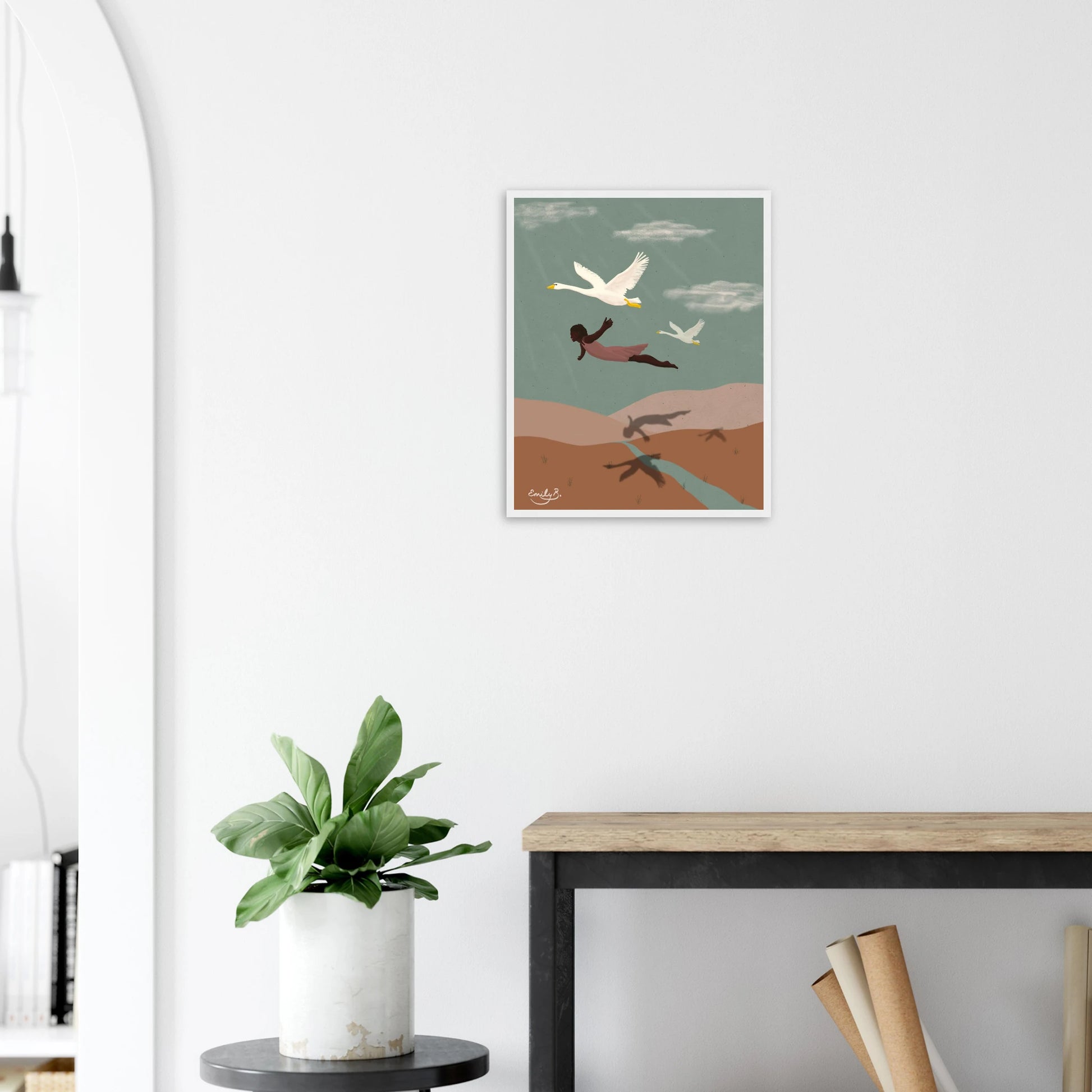 Framed illustrated wall art showing a woman flying with swans by Emily B. Studio